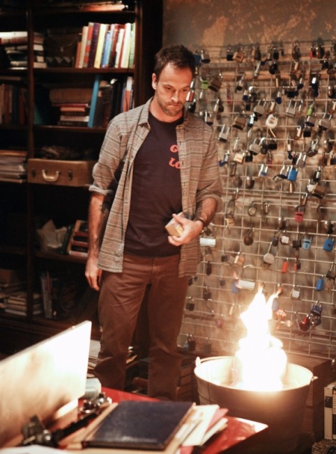 Sherlock Holmes (Jonny Lee Miller) brûle ses affaires en plein milieu de son salon pour se libérer la tête.